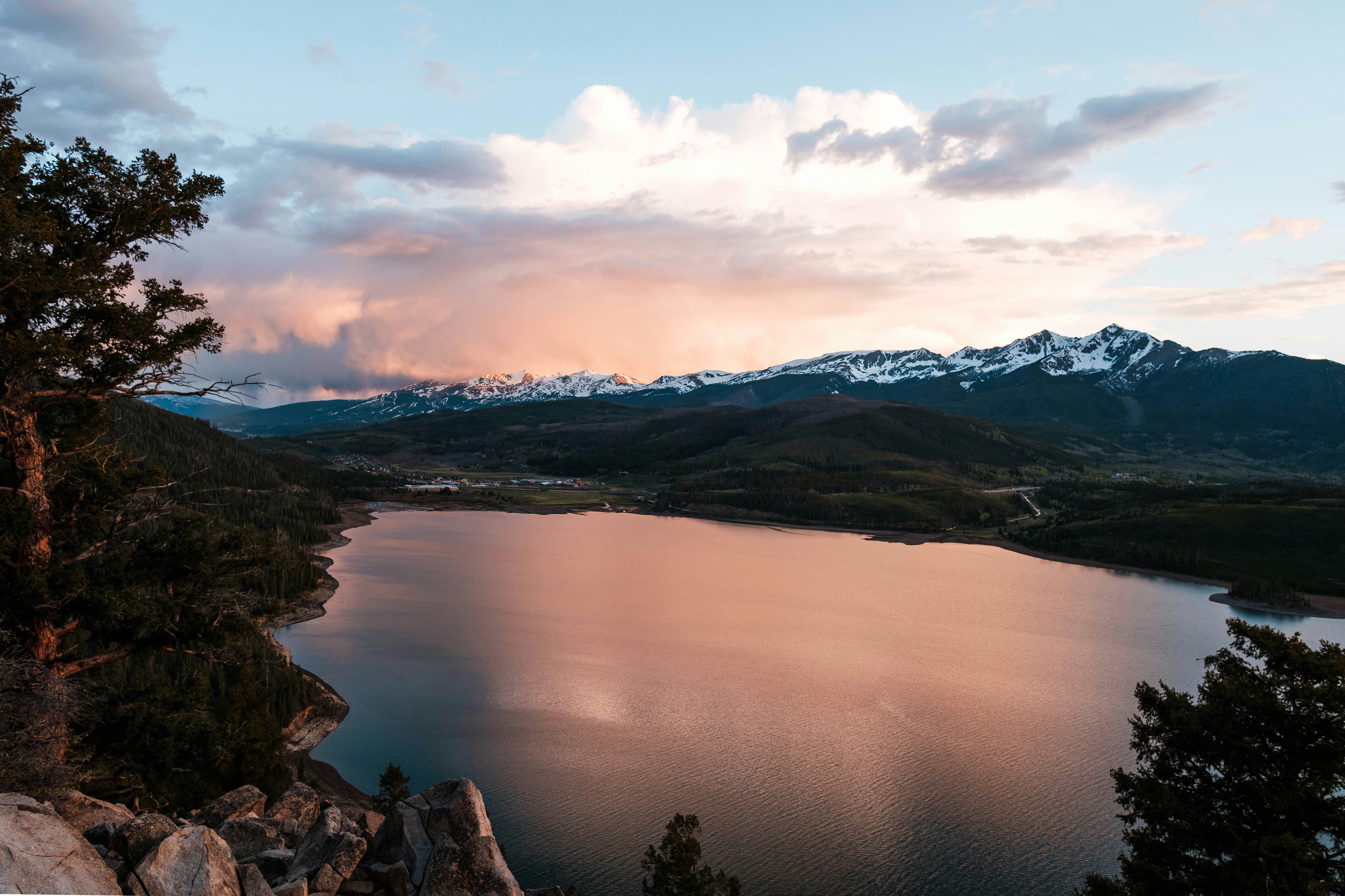 lake near mountain under cloudy sky during daytime